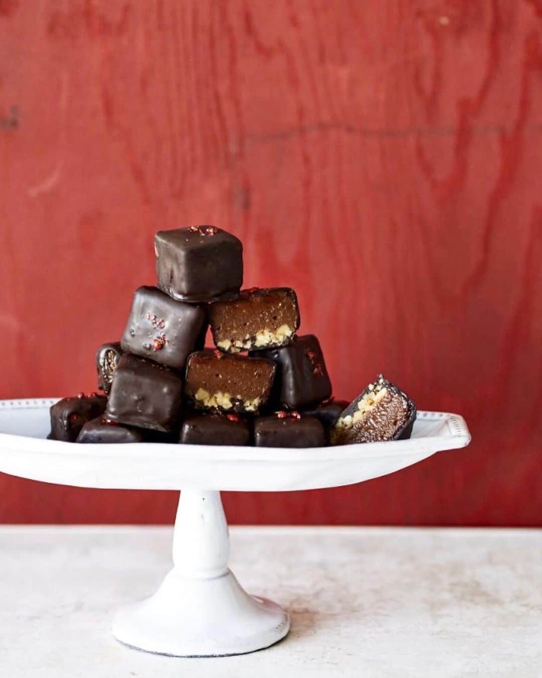 ケリーのインスタグラム：「Kelly’s Recipe BITORE MESHI  Healthy Chocolate for Valentines Day😍❤️🍫 ・ “Chocolate Truffle ” インスタにもレシピをアップしますね❣️ ・ 材料25個分  カシューナッツ……１７０ｇ カカオバター……７０ｇ ＜A＞ メープルシロップ……1/2カップ １００％カカオパウダー……大さじ２ シナモンパウダー……小さじ1/4 チリパウダー……小さじ1/8 塩……少々 バニラエッセンス……少々 くるみ……１００ｇ ＜B> はちみつ……大さじ１ 塩……少々 ８０％ダークチョコレート……3枚 ピンクペッパー……適量 作り方は…  ～下準備～  ★15㎝角の底が外れる型を用意する。 ★カシューナッツを一晩（8時間～）浸水させる。 1.鍋に湯を沸かし、一回り大きなボウルをのせてカカオバターを加え中火で溶かす。 2.ブレンダ―にしっかり水気をきったカシューナッツ・①・Aを加え　なめらかになるまで攪拌する。 3.フライパンでくるみを炒り、粗熱をとって　粗みじん切りにする。 4.③にBを加え混ぜ、型に平らになるように敷く。その上に②を流し入れ、全体を平らにのばし、冷蔵庫で冷やし固める。 5.再び湯を沸かし、ボウルに砕いたダークチョコレートを入れて湯煎にかけて溶かす。  100％カカオは、抗酸化力があると言われるポリフェノールが豊富で、美容にとってもGOOD！ また、チリパウダーを加えることで、代謝をアップさせ、味のアクセントにもなります。食べると幸福感を得られるというチョコレートは、正しく取れば美しくなりたい私たちの味方なんです。  Happy Valentine’s Day 😗💗 ・ #valentinesday#バレンタイン #バレンタイン手作り」