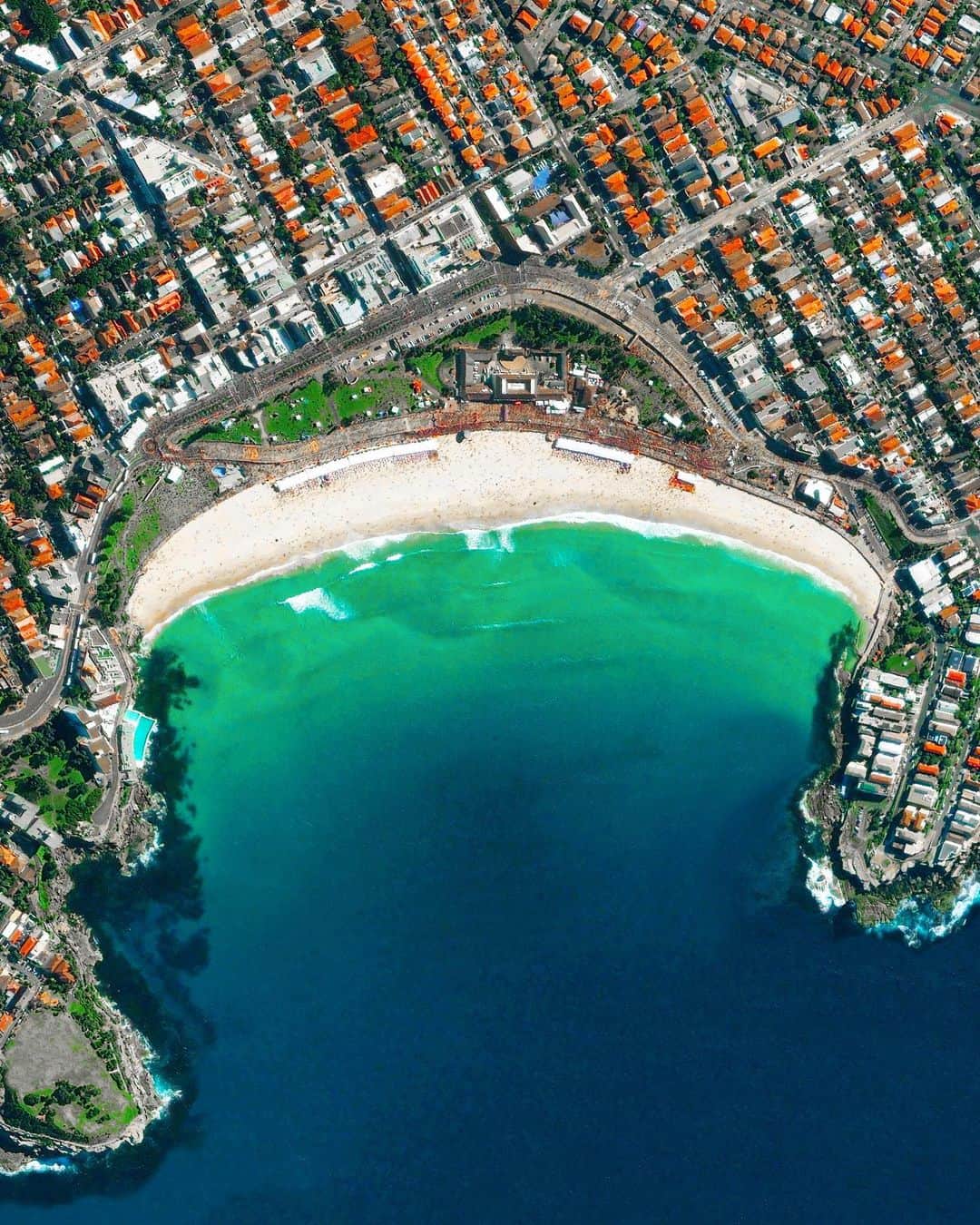 Daily Overviewのインスタグラム：「Bondi Beach is located in Sydney, Australia. One of the city’s most stunning and popular destinations, the beach gets its name from the Aboriginal word ‘Boondi’, meaning ‘waves breaking over rocks’. The beach’s surrounding neighborhood, which shares its name, is home to about 11,600 people. — Created by @overview Source imagery: @maxartechnologies」