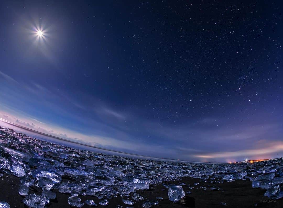KAGAYAのインスタグラム：「浜に打ち上げられた透明な氷たち。 月光に照らされ宝石のように光っていました。 写真右上にオリオン座と冬の大三角が写っています。 （2017年、北海道にて撮影） 今日もお疲れさまでした。 #星空 #北海道」