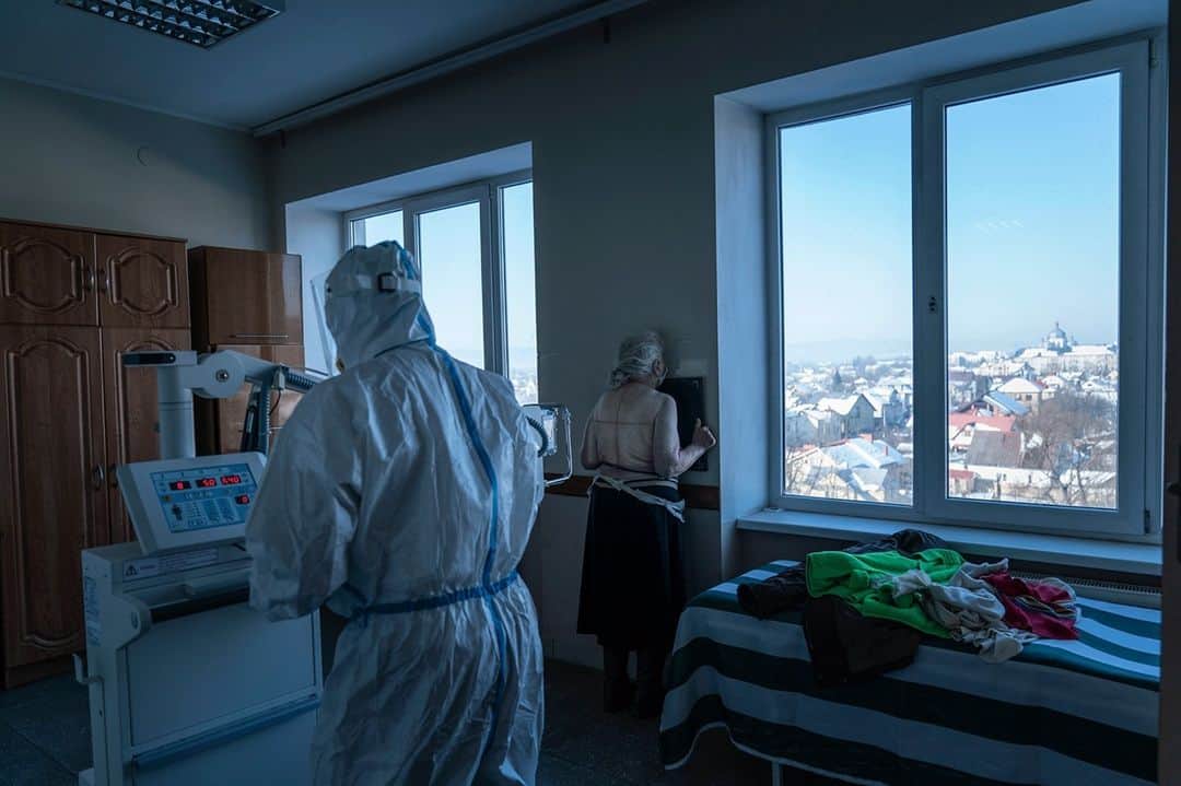TIME Magazineのインスタグラム：「A medic wearing a protective suit prepares a patient with COVID-19 for a lung X-ray at a hospital in Kolomyia, Ukraine, on Feb. 23. After several delays, Ukraine finally received 500,000 doses of the AstraZeneca vaccine on Tuesday, the first shipment of COVID-19 vaccine doses to the country. Ukraine has recorded 1.3 million cases and over 25,000 deaths so far, @apnews reports, and hopes to vaccinate 35% of the country's population this year. Photograph by @evgenymaloletka—@apnews」