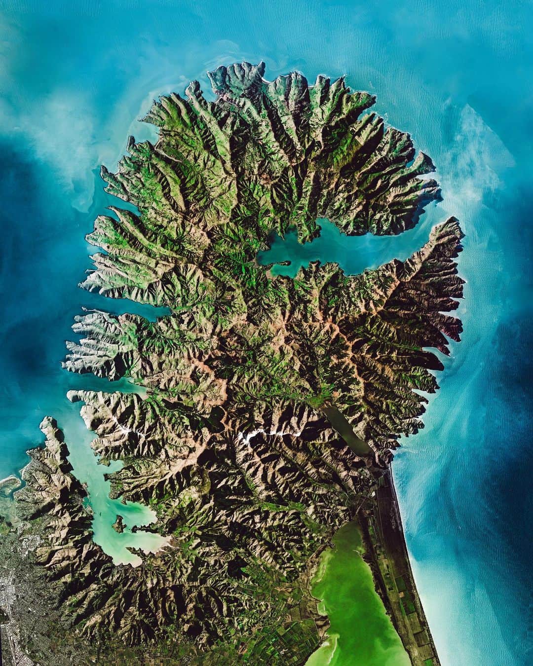 Daily Overviewのインスタグラム：「Check out this amazing Overview of the Banks Peninsula, which juts off the east coast of New Zealand's South Island. The landmass, which is volcanic in origin, has an area of roughly 440 square miles (1,150 sq. km) and encompasses two large harbors and many small bays and coves. It is believed that forests once covered 98% of the Banks Peninsula, yet — as the result of deforestation — less than 2% of the native forest cover remains today. — Created by @overview Source imagery: @planetlabs」