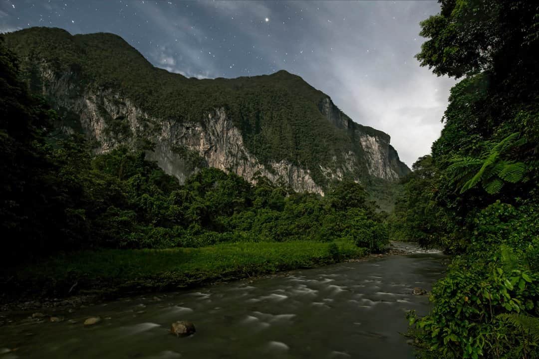 National Geographic Travelのインスタグラム：「Photo by Robbie Shone @shonephoto / During the scientific research expedition to Borneo's Gunung Mulu National Park in 2018, the team spent a week based on the banks of the Melinau River at Camp 5 in the Melinau Gorge. Camp 5 is a small wooden structure nestled in the gorge between two massifs, Mount Benarat (pictured) and Mount Api. This base offered the team a great starting point to access the nearby caves where the scientists had several sampling sites. At the end of every long and tiring day, it was an amazing feeling to relax while gazing up at the white cliffs of limestone exposing several cave entrances. I remembered climbing to them and exploring the maze of cave passages inside the mountain on previous expeditions some 10 years ago.」